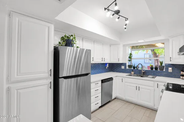 a kitchen with stainless steel appliances granite countertop a stove a sink and a refrigerator