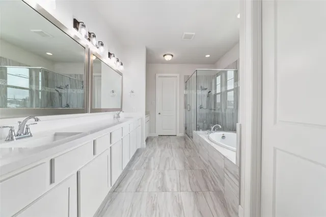 a spacious bathroom with a double vanity sink a large mirror and shower