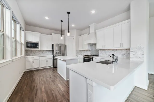 a kitchen with white cabinets and stainless steel appliances