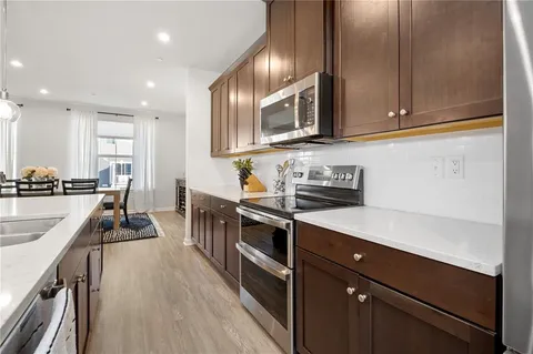 a kitchen with stainless steel appliances sink stove microwave and cabinets