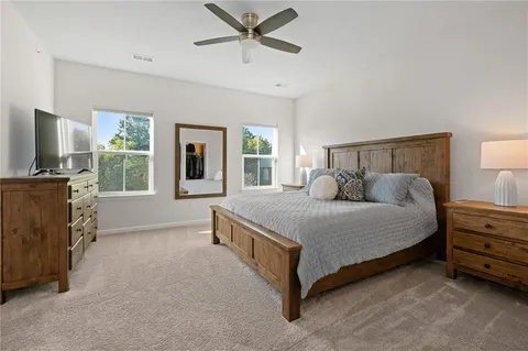 a spacious bedroom with a bed and a flat screen tv