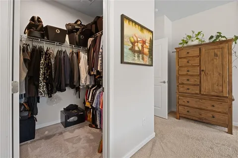 a view of walk in closet with clothes and shoes