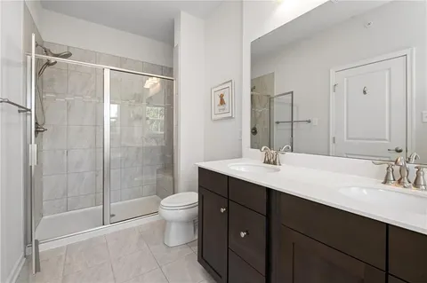 a bathroom with a double vanity sink toilet and shower