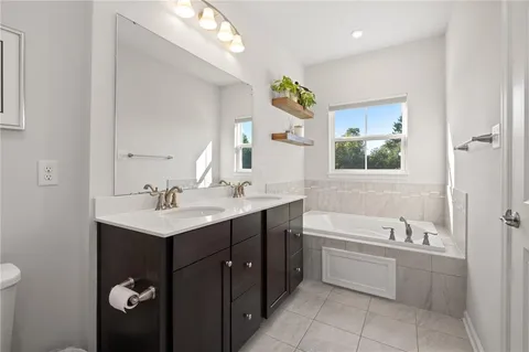 a bathroom with a tub a sink and mirror