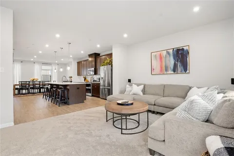 a living room with furniture and kitchen view