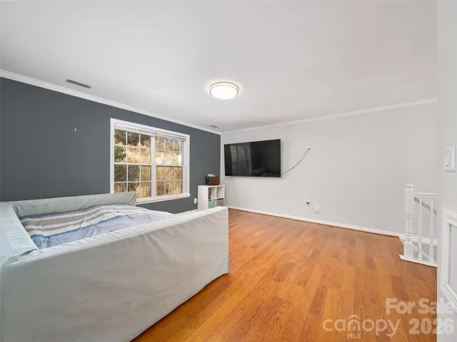 a spacious bedroom with a bed and a flat screen tv