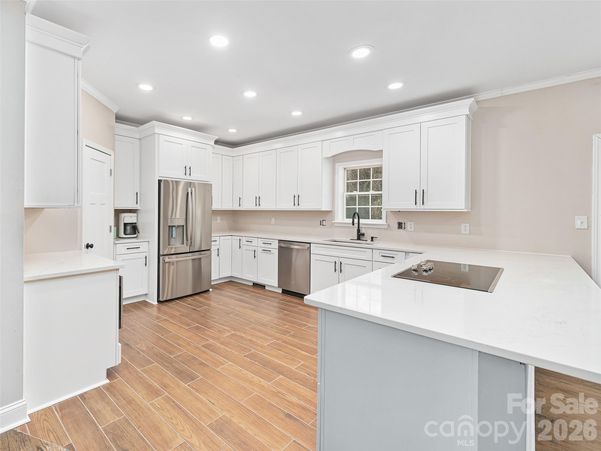 221 Creed Pitman Road Spruce Pine, NC 28777 - Photo 6 of 27 a kitchen with white cabinets and white appliances