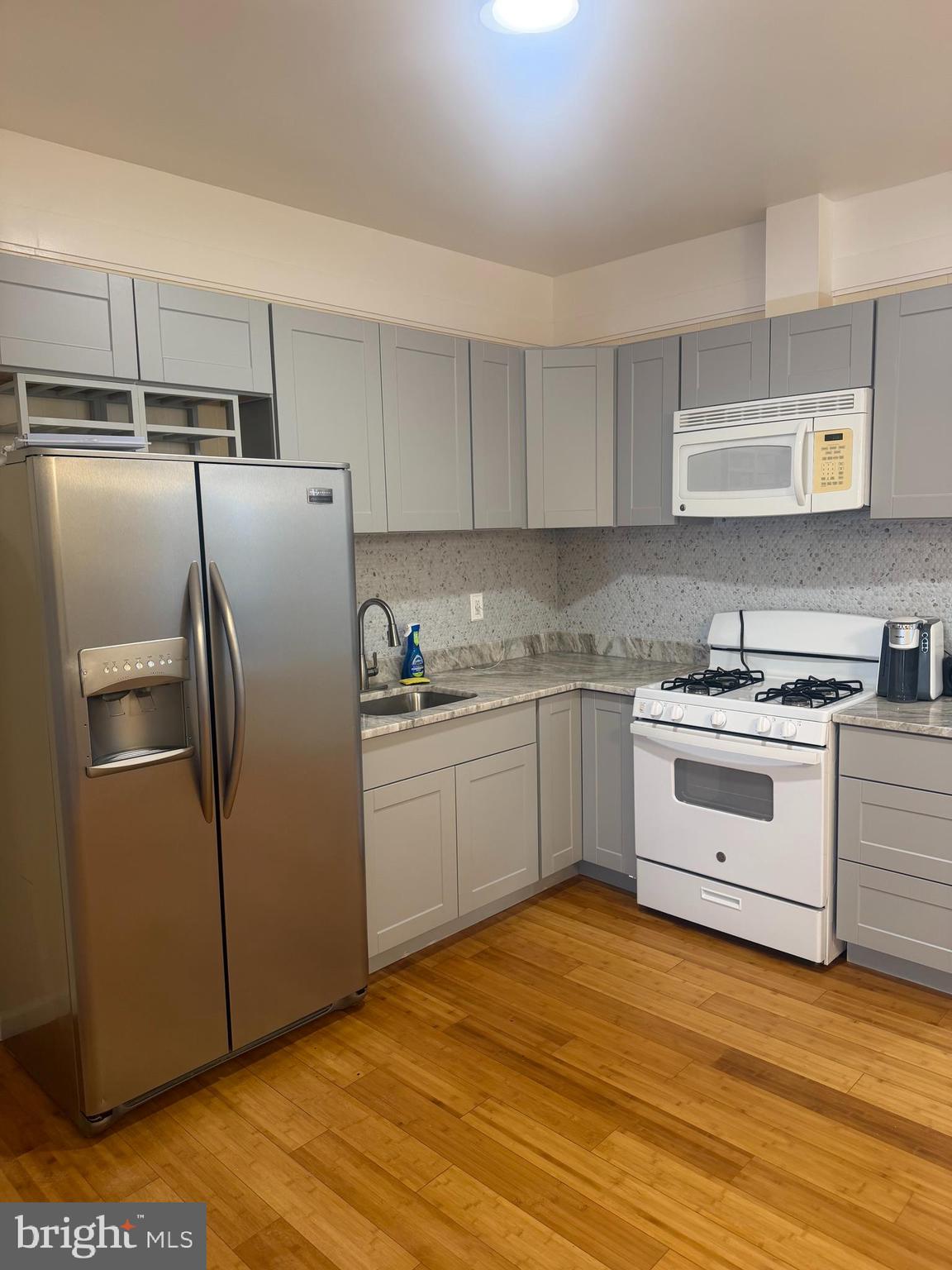 1940 South 57th Street Philadelphia, PA 19143 - Photo 3 of 26 a kitchen with a refrigerator stove and white cabinets
