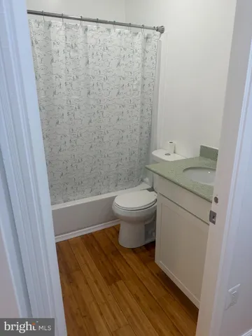 a bathroom with a granite countertop white toilet and a sink