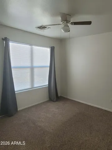an empty room with windows and fan