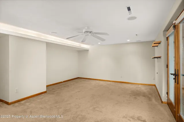 an empty room with a ceiling fan and a window