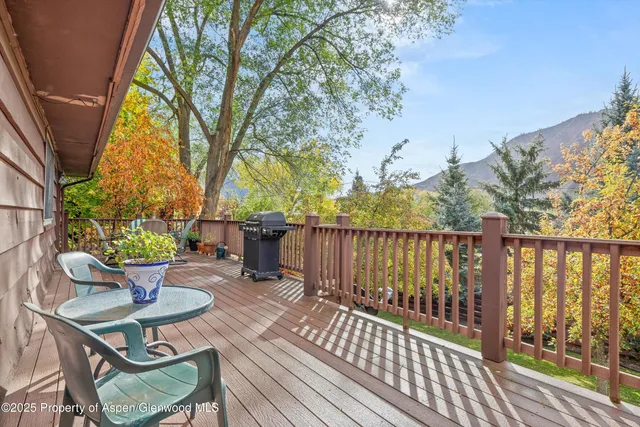 a view of a balcony with wooden floor and outdoor seating