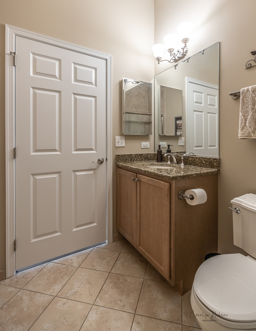 3870 Eagle Ridge Drive Elgin, IL 60124 - Photo 17 of 20 a bathroom with a granite countertop sink a toilet mirror and vanity
