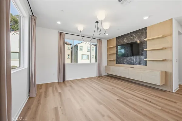 a kitchen with stainless steel appliances granite countertop a refrigerator a stove and a sink with wooden floor