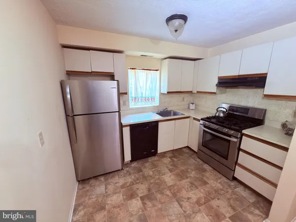 a kitchen with a refrigerator sink and cabinets