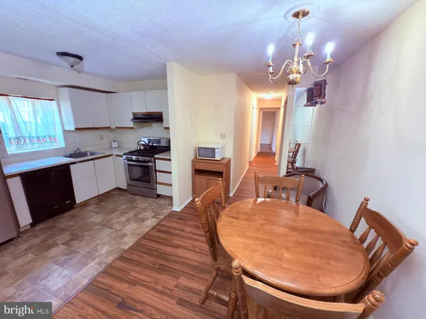 a large kitchen with kitchen island a stove a sink a refrigerator dining table and chairs