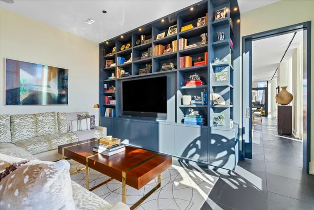 a living room with furniture a flat screen tv and a bookshelf