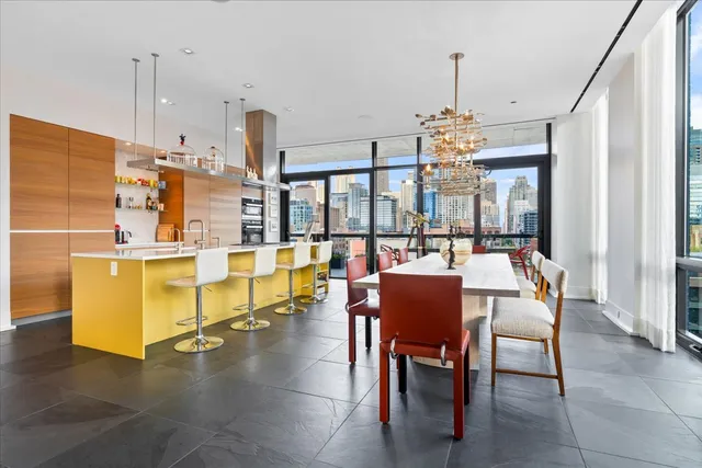 a dining room with furniture a chandelier and wooden floor