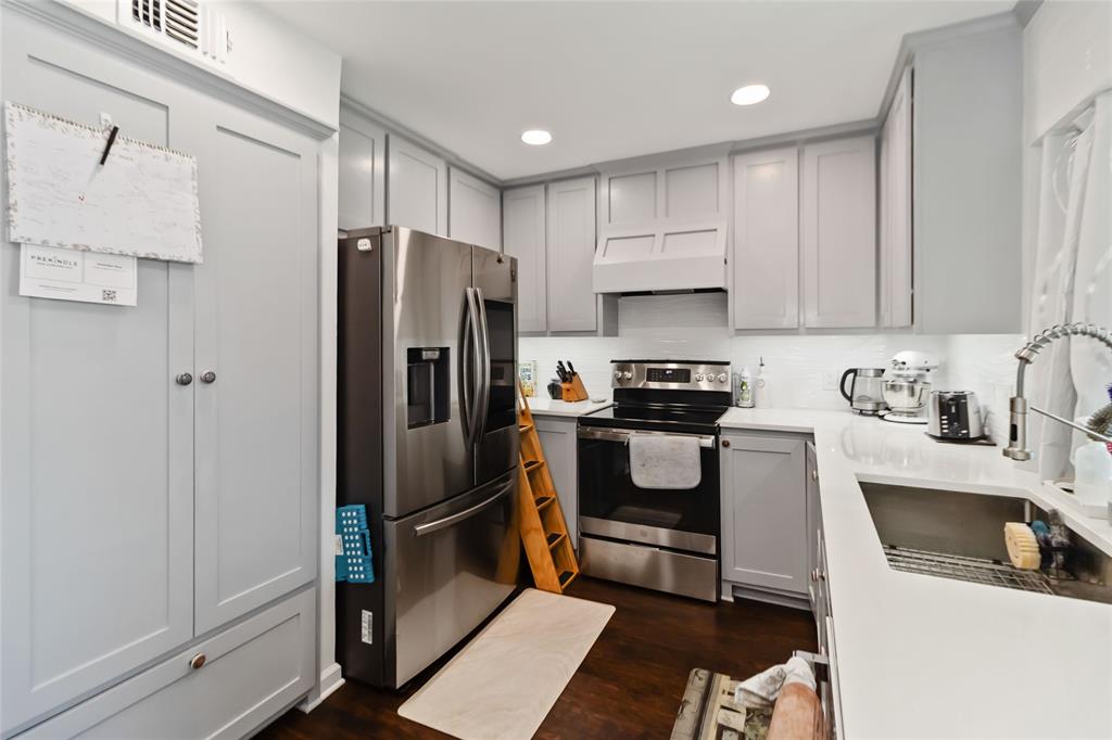 1920 Avignon Court Carrollton, TX 75007 - Photo 12 of 31 Kitchen featuring gray cabinetry, appliances with stainless steel finishes, recessed lighting, dark wood-style flooring, and tasteful backsplash