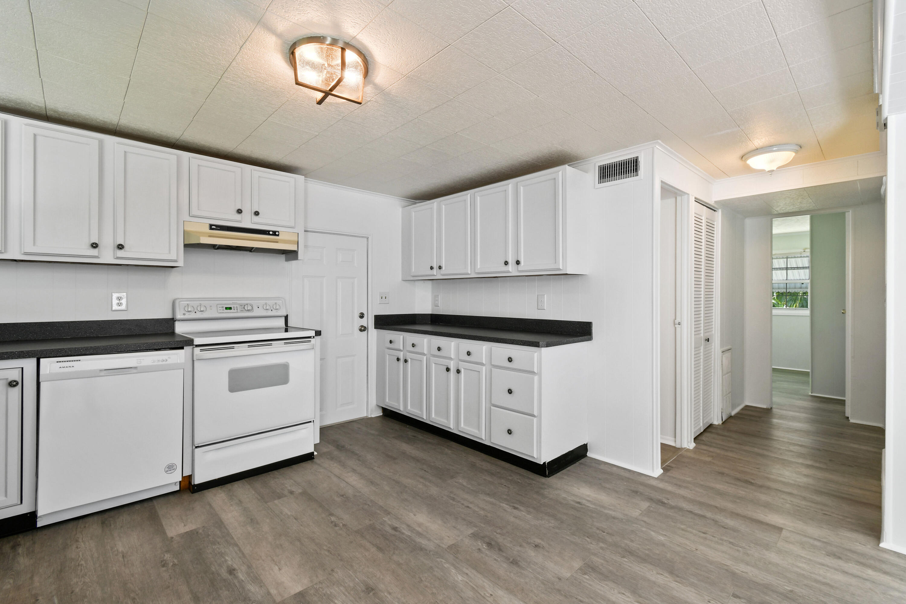 24 Southeast Fork Terrace Stuart, FL 34997 - Photo 7 of 14 a kitchen with granite countertop white cabinets and white appliances