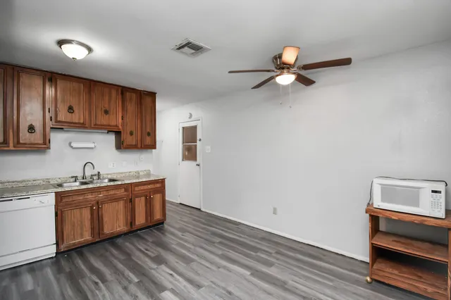 a kitchen with sink cabinets and wooden floor