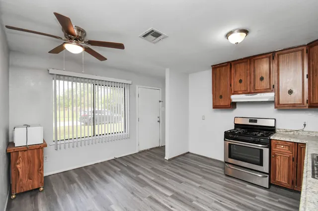 a kitchen with granite countertop a stove and a wooden floors