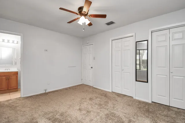 an empty room with closet and windows