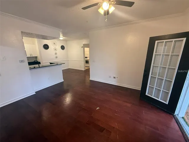 a view of a livingroom with wooden floor and a ceiling fan