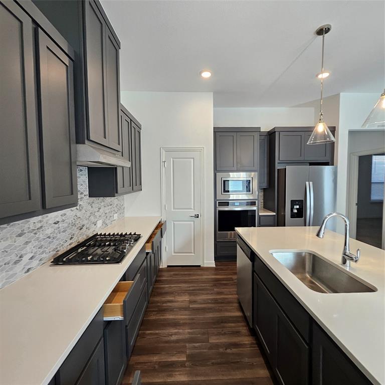 2309 Jack Rabbit Way Northlake, TX 76247 - Photo 2 of 28 Modern kitchen featuring dark gray cabinetry, stainless steel appliances, and wood-finish flooring