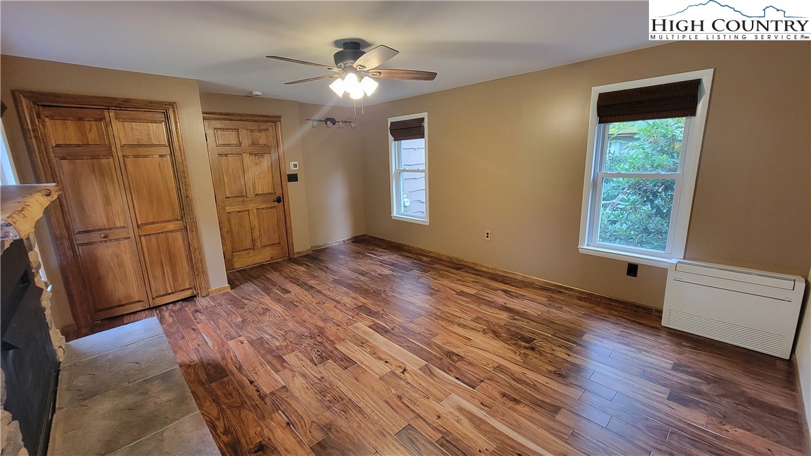 252 Goshen Creek Lane Boone, NC 28607 - Photo 3 of 31 an empty room with wooden floor cabinet and windows