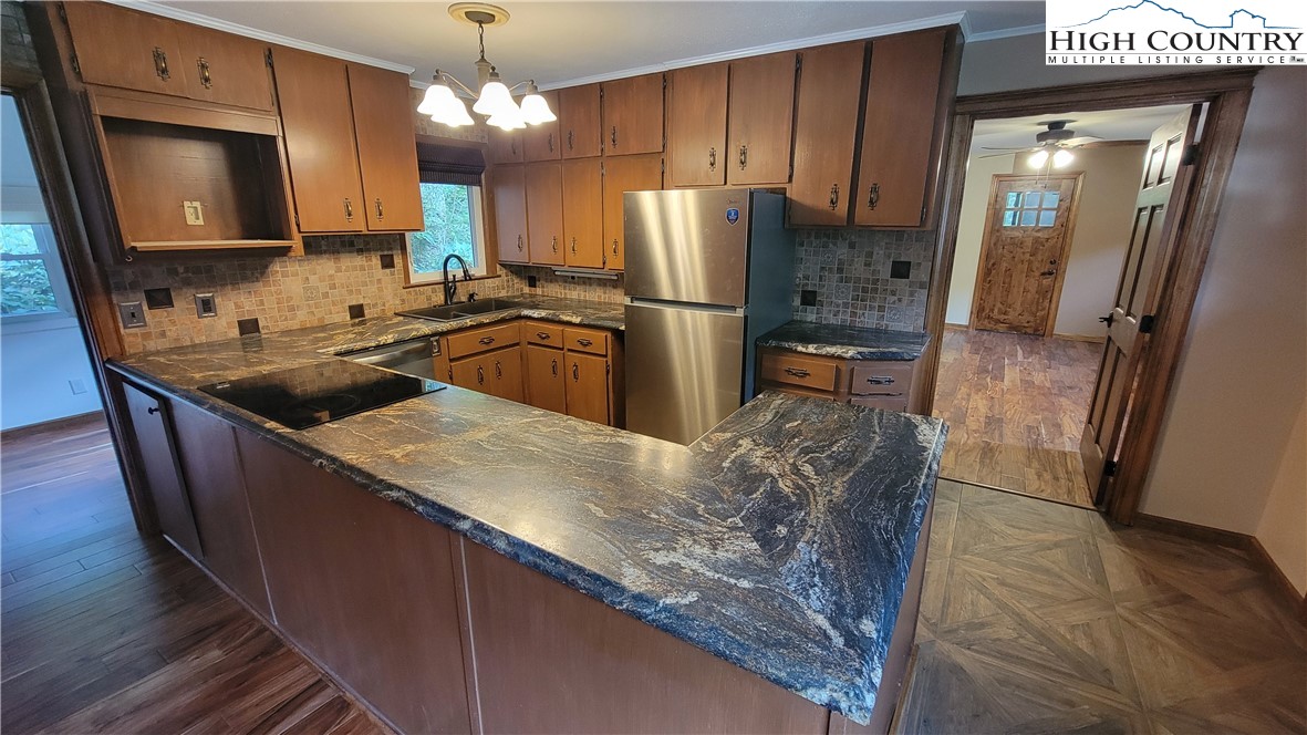 252 Goshen Creek Lane Boone, NC 28607 - Photo 6 of 31 a kitchen with stainless steel appliances granite countertop a refrigerator a sink and wooden cabinets