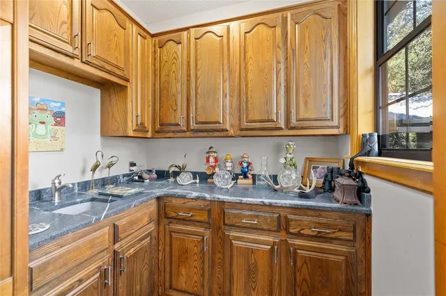 a kitchen with stainless steel appliances granite countertop a sink a stove and cabinets