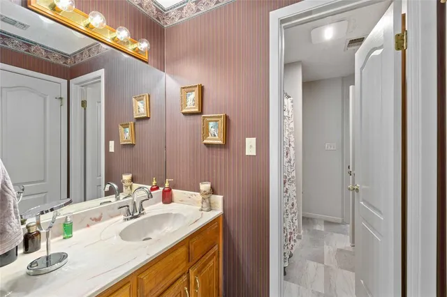 a bathroom with a sink vanity granite and a mirror