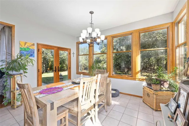a dining room with furniture a chandelier and wooden floor
