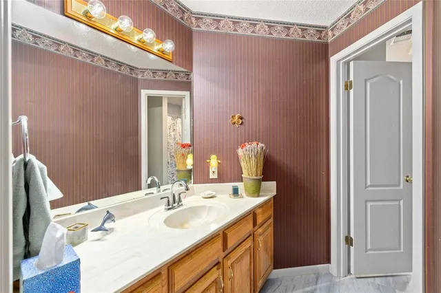 a bathroom with a sink vanity granite and a mirror