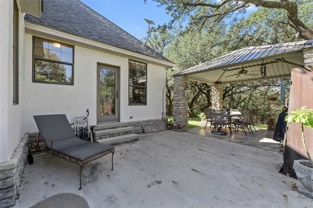 a view of a patio with table and chairs with wooden fence and plants