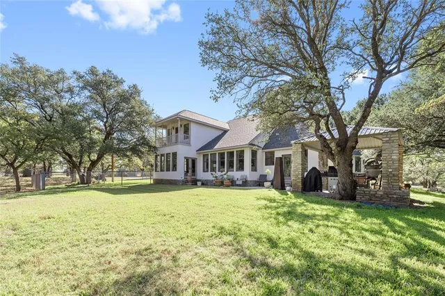 a view of a house with a yard and large trees