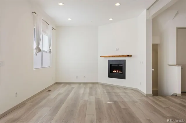 a view of an empty room with a fireplace and a window