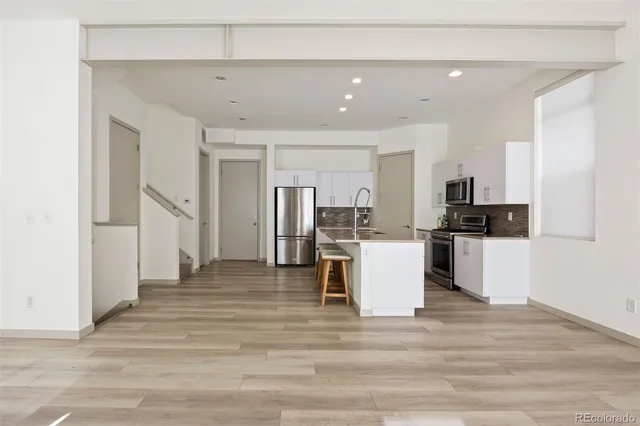 a view of kitchen with refrigerator microwave and stove