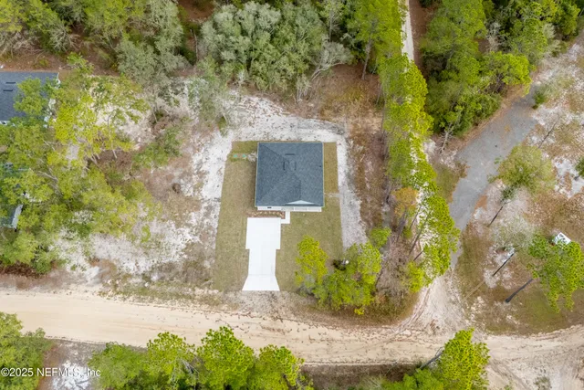 a view of a house with backyard and trees