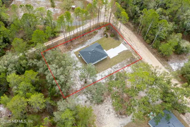 an empty room with wooden floor kitchen view and a ceiling fan