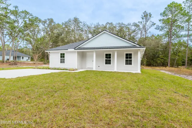 a front view of a house with yard and trees