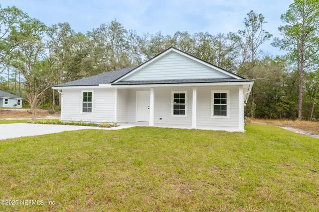 a view of a house with yard and trees