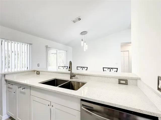 a kitchen with granite countertop a sink and cabinets