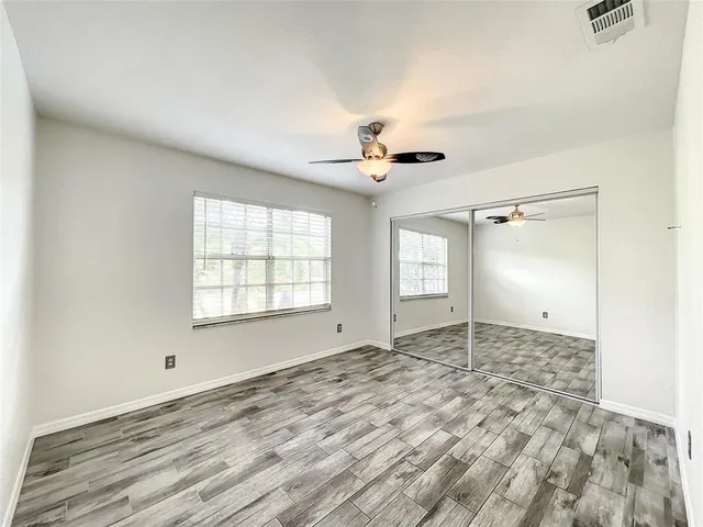 a view of empty room with wooden floor