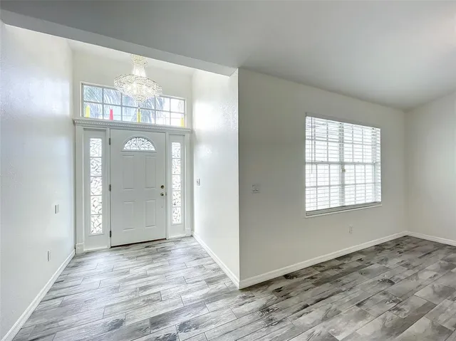 a view of empty room with wooden floor and window