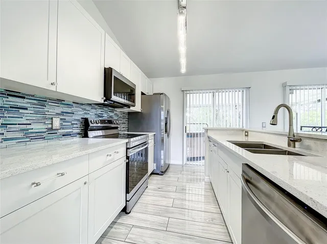 a kitchen with stainless steel appliances a stove a microwave and a refrigerator