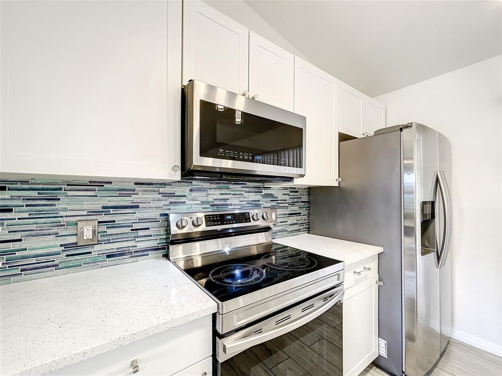 2887 Southwest Ann Arbor Road Port St. Lucie, FL 34953 - Photo 10 of 31 a kitchen with stainless steel appliances a stove a microwave and a refrigerator