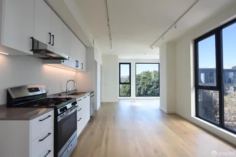 a kitchen with granite countertop a stove and wooden floor