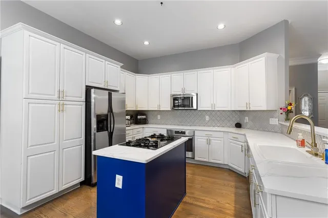 a kitchen with stainless steel appliances a refrigerator stove microwave and sink